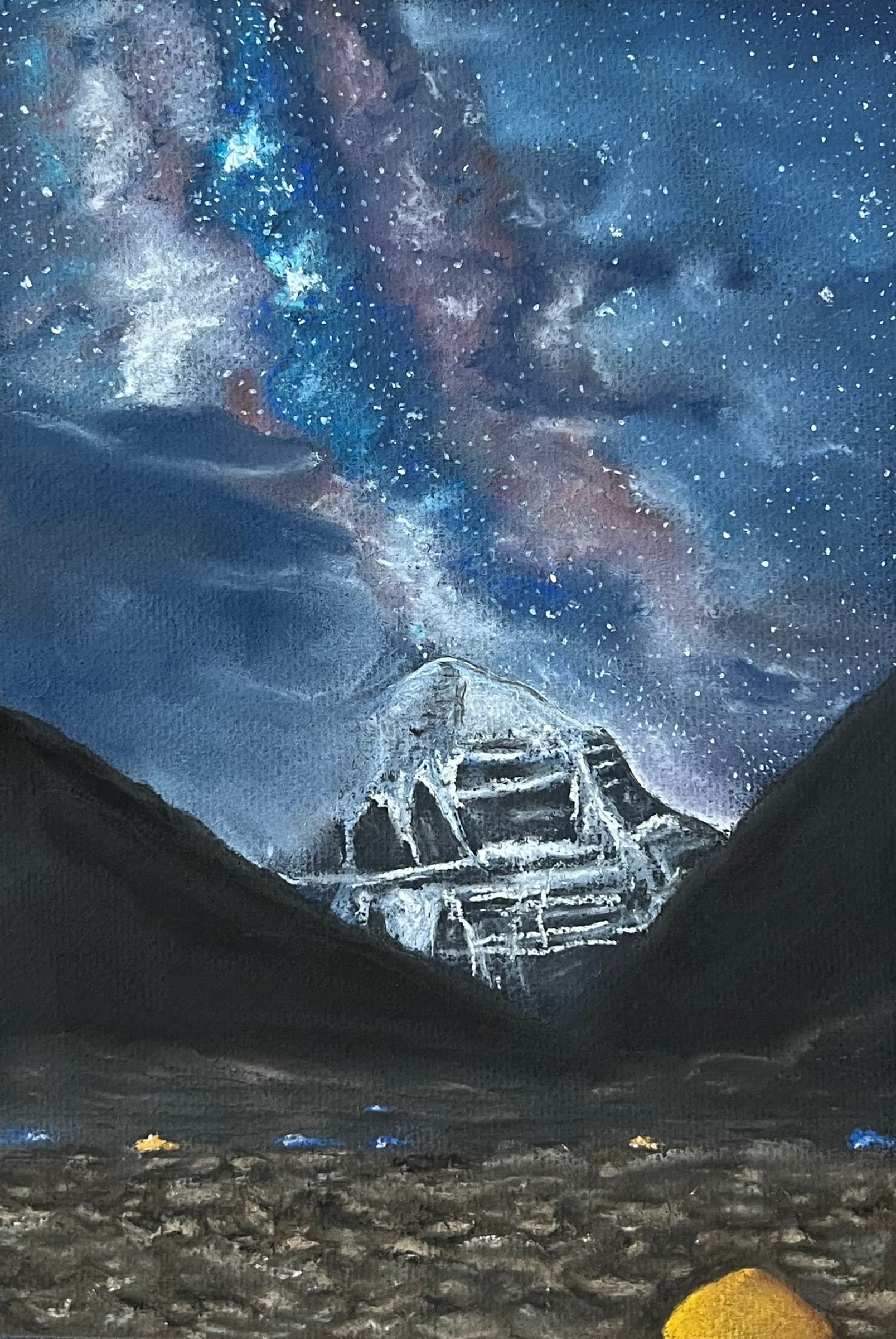 Mount Kailash, its snow faces glowing, stands between dark slopes beneath the Milky Way; small tents glow yellow in the foreground.