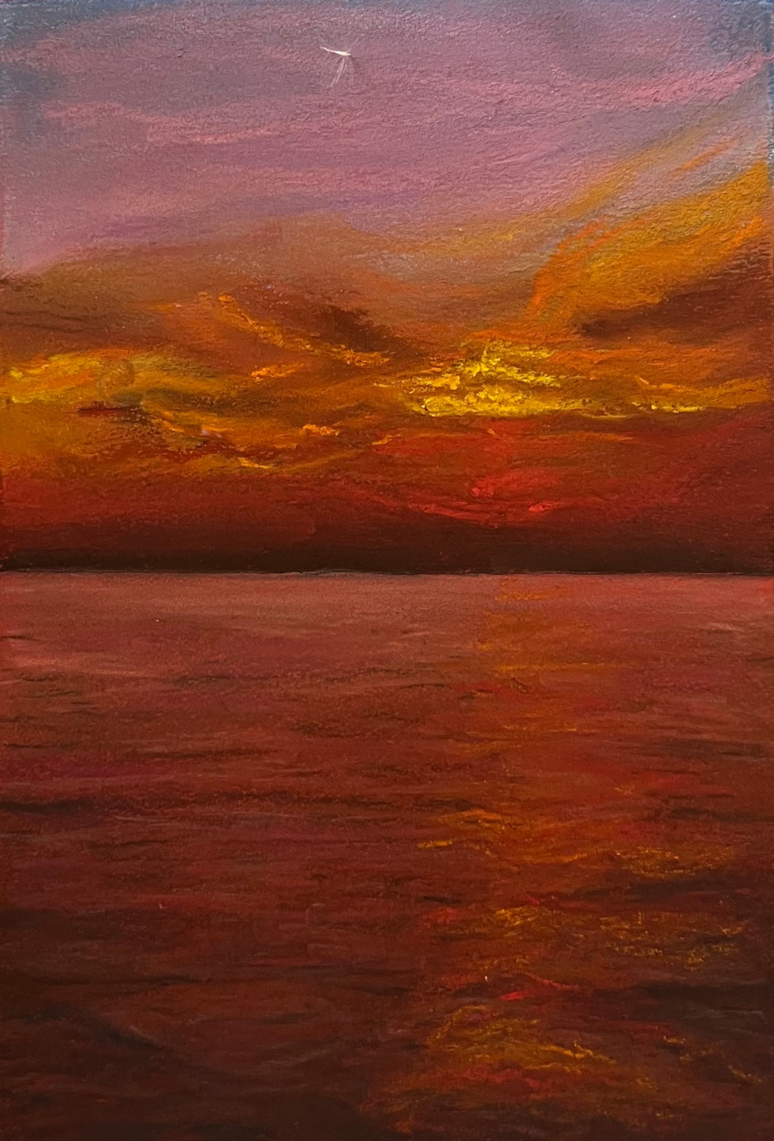 A still sea glows deep red beneath a lavender sky and a band of golden cloud at dusk; a single bird crosses high above.